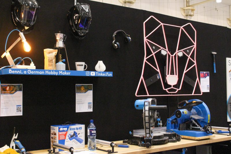 Maker-Werkbank mit Werkzeugen und geometrischer Bärenkopf-Neonkunst